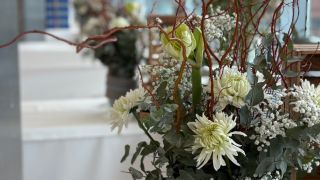 Bunte Auswahl frischer Schnittblumen in Vasen, Rosen, Hortensien und Allium dicht arrangiert auf einem Verkaufstisch